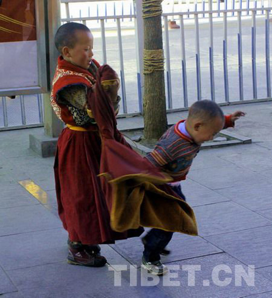 Tsering Dorje is playing with his younger brother on the road from the Potala Palace. [Photo/China Tiet Online]