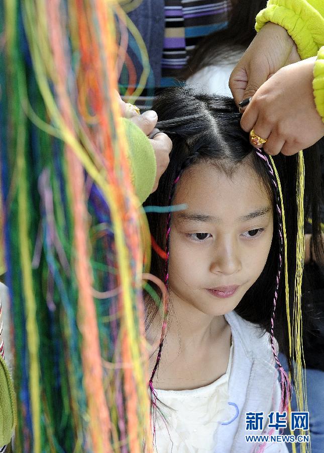 Photo taken on August 21st shows that two local Tibetan women are braiding hair for a tourist. [Photo/Xinhua]