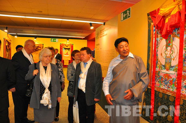 Visitors view Thangka paintings during the opening ceremony of the 2013 Germany China Tibetan Culture Week in Berlin, Germany on Oct. 23, 2013.
