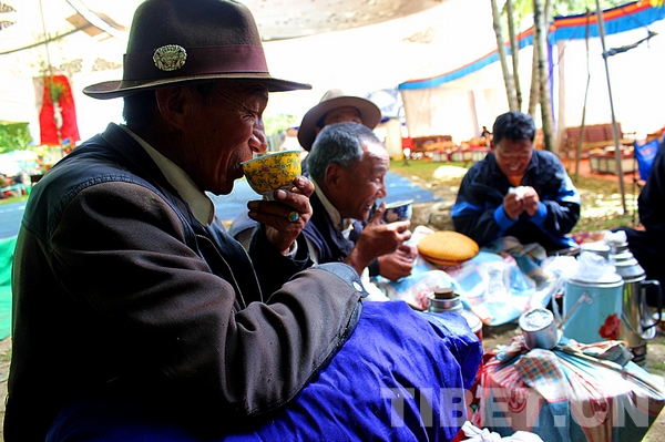 Peopel drink home made butter tea to enjoy "lingka", which means parks in Tibetan language. [Photo/China Tibet Online]