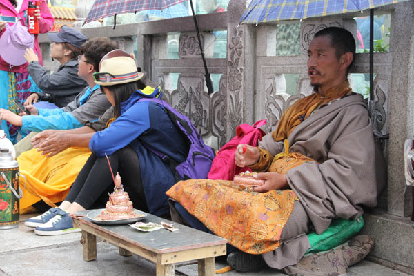 Photo shows a Tibetan Buddhist practicing a Tantra (Esoteric Buddhism) ritual as a personal Buddhist cultivation in front of the Jokhang Temple. [Photo/China Tibet Online]