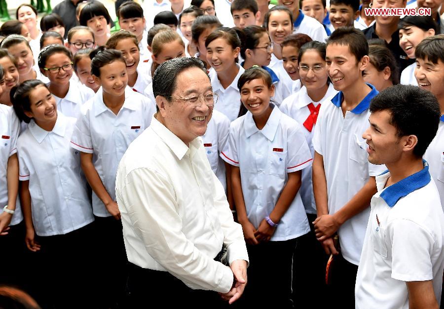 Yu Zhengsheng (C front), chairman of the National Committee of the Chinese People's Political Consultative Conference, visits students from Xinjiang Uygur Autonomous Region at the Changqing No. 1 Middle School in Jinan, east China's Shandong Province, Sept. 13, 2014. Yu made a research and inspection tour in Shandong on Sept. 12 - 15. (Xinhua/Liu Jiansheng)