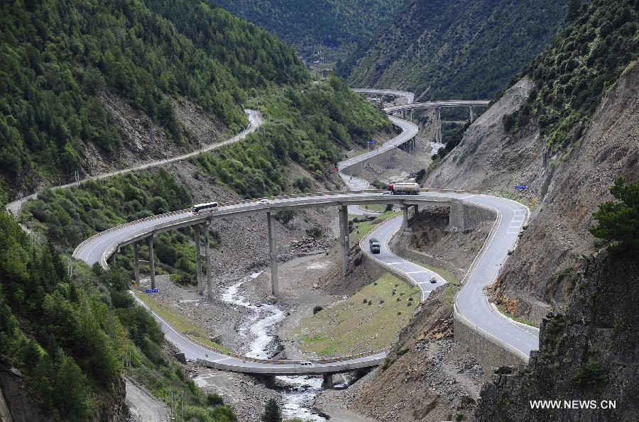 Photo taken on Sept. 14, 2014 shows a bridge of the East Guro - Haizishan Road in the Tibetan Autonomous Prefecture of Garze, southwest China's Sichuan Province. The mountain road is dubbed as "the Chinese Landscape Avenue" thanks to the beautiful scenery along the road. Since 2011, China has invested 4.5 billion RMB yuan (733 million U.S. dollars) to upgrade the road in order to improve the traffic safety. The upgrade project is expected to be completed in the beginning of 2015. From then on , travel time between East Guro and Haizishan will be shortened to 5 hours from 10 hours. (Xinhua/Liu Kun)
