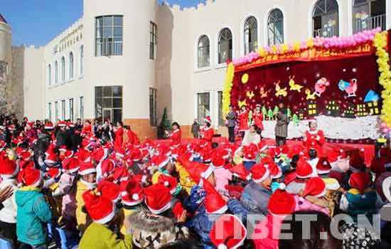 The teacher announces in Tibetan, Mandarin and English respectively for the child-parent party on the Christmas in MingZhu Kindergarten in Lhasa, southwest China's Tibet. [Photo by Yang Xu/China Tibet Online]
