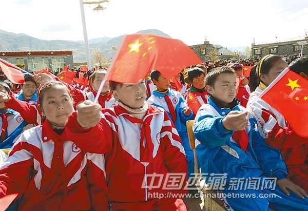 Tibetan pupils wave red flags while watching the theoretic performance staged in Khesum Village, known as Tibetan first domestic reform village, to celebrate Tibetan Serfs Emancipation Day on March 27, 2012. [Photo/Chinatibetnews.com]