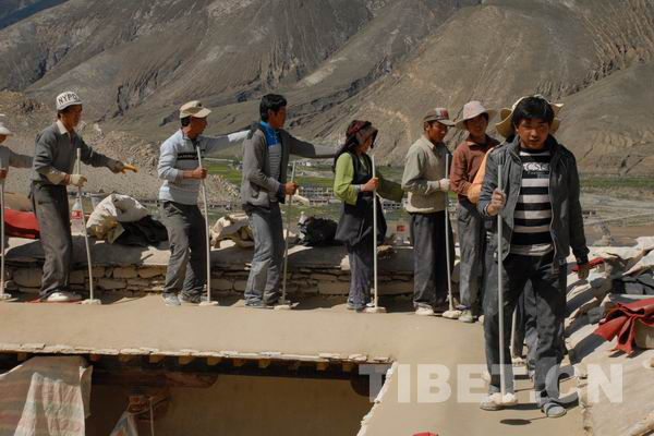 Construction workers tamp the Aga clay at Pingcuolin Monastery in Shigtse Prefecture, Tibet Autonomous Region, photo from China Tibet Online.