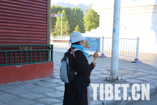 In the morning, a prayer walker tracks around in downtown Lhasa. [Photo/Tibet.cn]