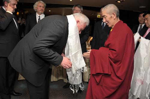 The Living Buddha of Kumbum Monastery presents the white hada scarf to Lithuanian parliament member in Vilnius, capital of Lithuanian, March 28. [Photo/Xinhua]